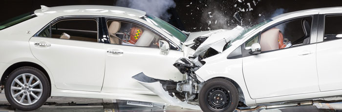 Two white cars crashing head on in test environment