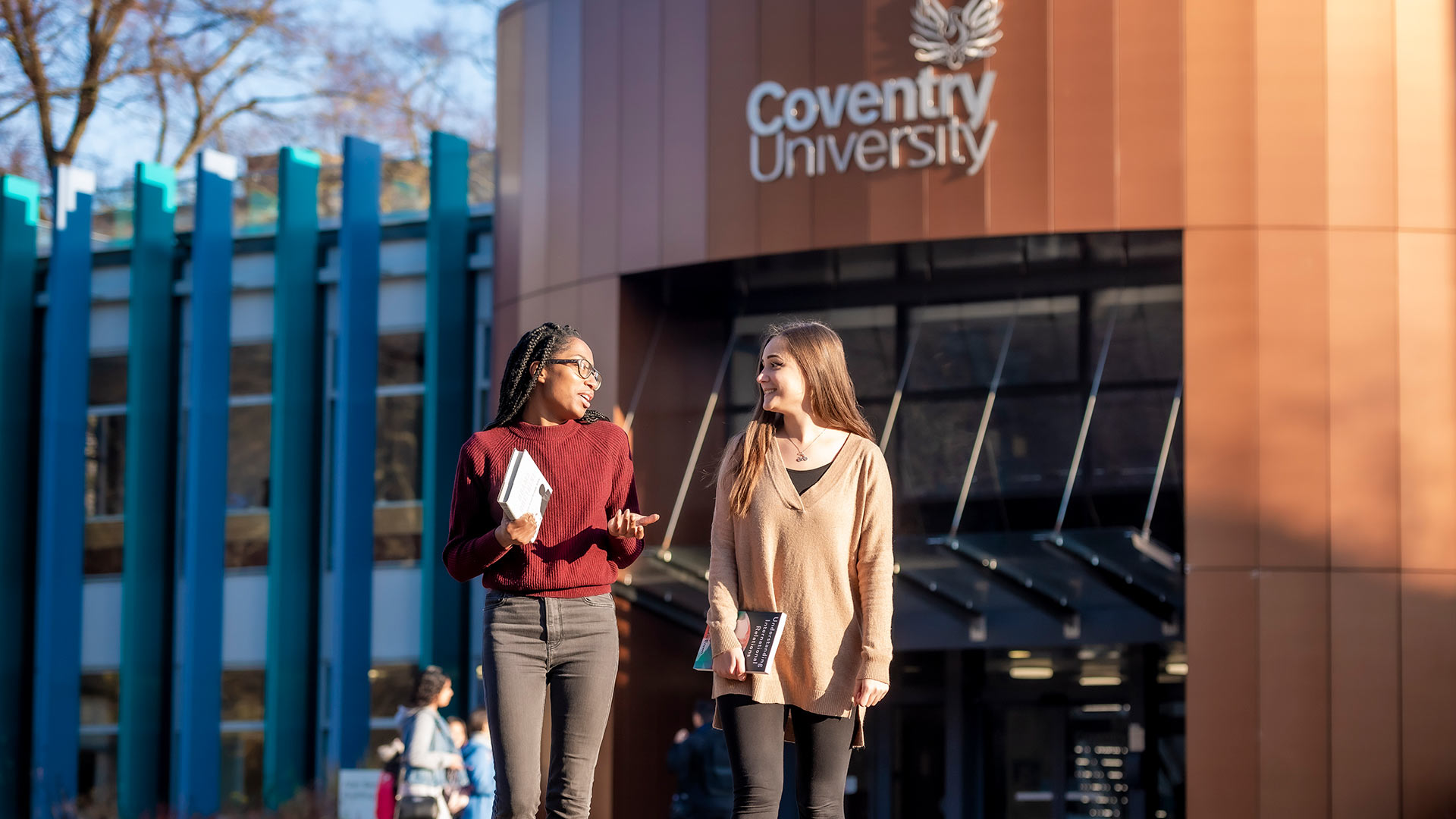 Two students talking outside a university building
